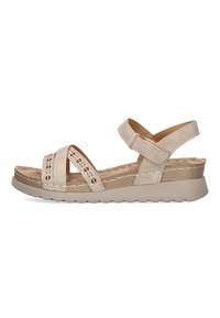 Sandalia beige con tiras entrecruzadas y cortes decorativos. Cuenta con un tacón cuña con un acento de yute texturizado y tira trasera ajustable.