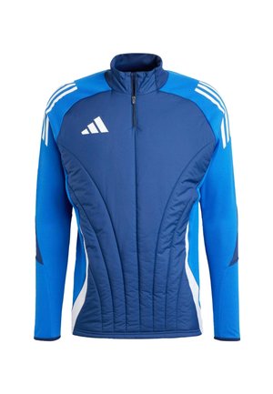 Blaue Sportjacke mit hohem Kragen, Reißverschluss vorne, gestepptem Material, weißen seitlichen Einsätzen und drei weißen Streifen auf den Schultern.