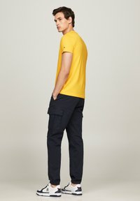 Tommy Hilfiger TOMMY LOGO TEE - Camiseta estampada - eureka yellow
