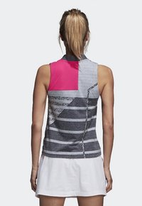 Haut de sport sans manches avec un mélange de rayures grises et une section rose au col, comportant des motifs texturés et une coupe ajustée.
