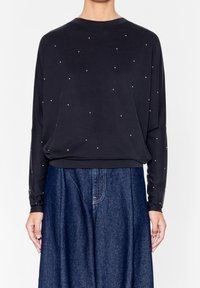 Maglietta nera a maniche lunghe con una vestibilità comoda, caratterizzata da decorazioni brillanti simili a gemme sparse sulla parte anteriore e un collo rotondo.