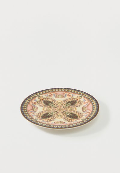 Assiette ronde en céramique avec des motifs complexes de paisley et floraux en vert, orange et violet sur un fond crème avec une bordure décorative.