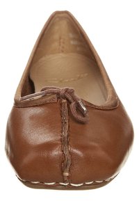 Bruine lederen ballerina's met een ronde neus, voorzien van een klein strikje en een gestikte naad in het midden. Zachte binnenvoering.