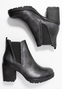 Černé kožené kotníkové boty s masivním podpatkem, elastickými bočními panely a strukturovanou gumovou podrážkou. Hladký povrch s kontrastním stehem.