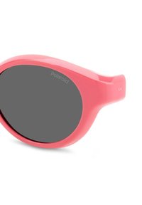 Occhiali da sole rosa in plastica con lenti ovali e tonalità grigia. Presentano il marchio Polaroid sulla lente e una superficie liscia e lucida.
