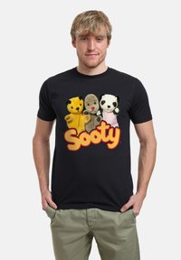 Černé bavlněné tričko s barevně vyšívanými postavičkami: žlutý medvěd, šedý pes a černá panda, s logem "Sooty" v žluté barvě.