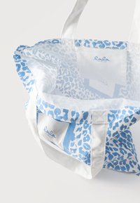 Λευκή και μπλε τσάντα tote με λεοπάρ σχέδιο, λευκές λαβές και λογότυπο "lala Berlin" στις εσωτερικές και εξωτερικές υφασμάτινες πλευρές.