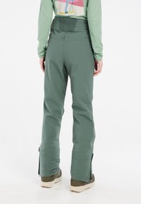 Groene waterdichte skibroek met een relaxte pasvorm, voorzien van een gestructureerde tailleband, zijritsen bij de enkels en duurzaam, rekbaar materiaal.