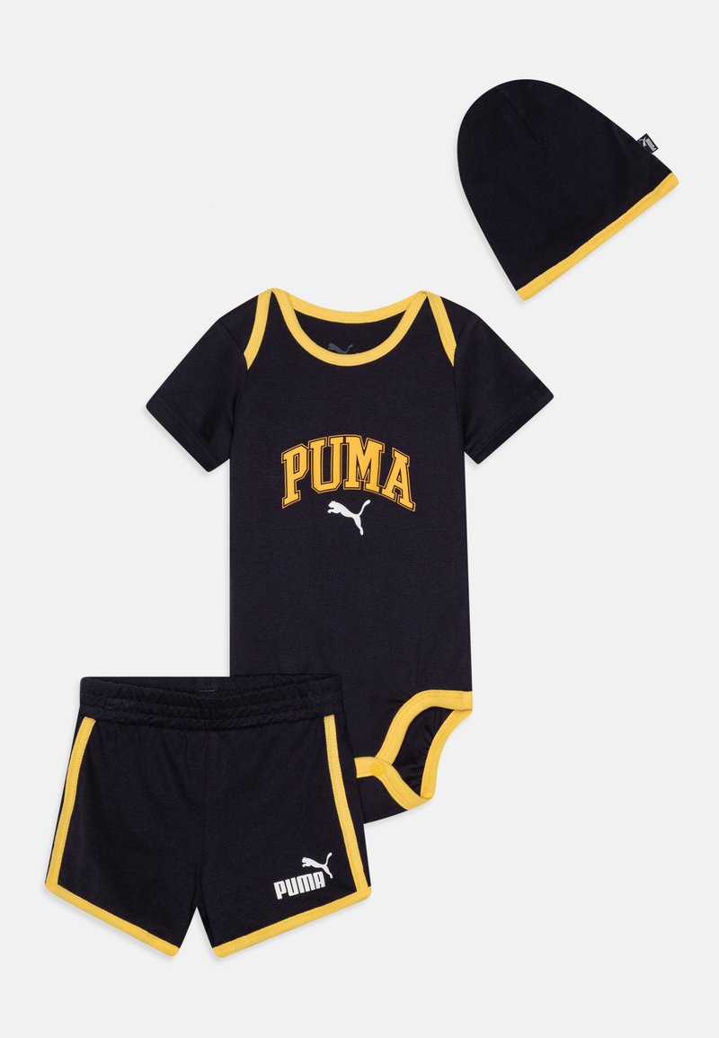 Svart bomulls babyantrekk med gul trim, inkludert en kortermet bodysuit, shorts og en matchende lue, alle merket med "PUMA."
