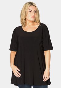 Sort tunika med rund halsudskæring, korte ærmer og løs pasform. Fremstillet af blødt materiale, har den en flydende silhuet.