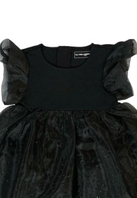 Czarna sukienka z dopasowanym gorsetem i rozkloszowaną spódnicą. Ramiona zdobią bufiaste rękawy wykonane z tiulu. Spódnica ozdobiona jest błyszczącymi koralikami.
