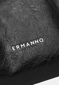 Borsa in pelle nera tessurizzata con un prominente logo bianco "ERMANNO" e "FIRENZE" sotto di esso, che mette in evidenza un design elegante e moderno.