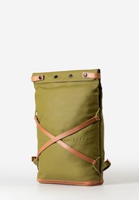 Zaino verde con chiusura a roll-top e cinghie in pelle marrone che incrociano la parte anteriore, chiusure a scatto in metallo e dettagli del logo in rilievo sul lato.