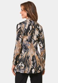 Blumenmuster, langärmlige Jacke in Schwarz-, Beige- und Grautönen. Weicher Stoff mit taillierter Passform, die einen ausgestellten Saum und einen dezenten Glanz aufweist.