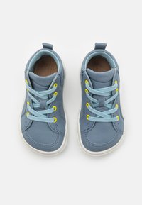 Blaue High-Top-Sneaker aus strukturiertem Material mit hellblauen Schnürsenkeln, gelben Ösen und weißen Gummisohlen.