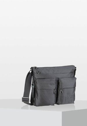 Sac bandoulière gris avec sangle réglable, deux poches avant zippées et tissu texturé posé sur une surface blanche.