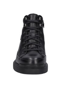Svart hög sportskor gjorda av strukturerat läder, med snörning framtill, metalögon och en platt gummisula med ett mönstrat mönster.