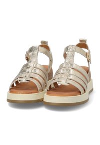 Sandali metallici dorati con design a più strap, punta aperta e suola chunky beige. Caratterizzati da una fibbia laterale per la regolazione.