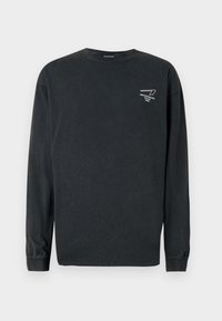 Black long-sleeve cotton t-shirt with a crew neck. Features a small white graphic on the left chest and ribbed cuffs. Slightly textured finish.