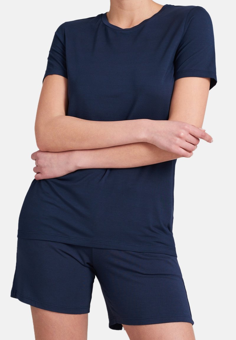 Marinblå t-shirt med kort ärm som matchas med korta byxor; mjukt, lättviktigt tyg med en slät textur och klassisk rundhalsringning.