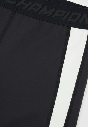 Pantalones cortos deportivos negros que presentan una cinturilla negra sólida con el logotipo "CHAMPION" en relieve. Incluyen acentos de panel lateral blanco y costuras en contraste.
