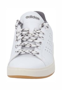 Vit sneaker med perforerade sidopaneler, grå detaljer och texturerad krämfärgad sula. Utrustad med grå och vita mönstrade snören samt adidas-logotyp.