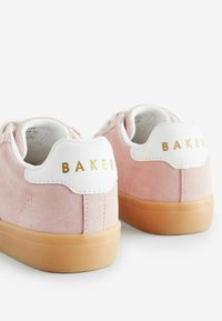 Tenisi roz din suede cu accente din piele albă și literă aurie „BAKER” pe toc. Prevăzuți cu talpă din cauciuc și un design cu vârf rotunjit.