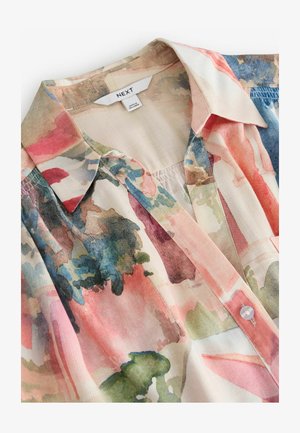 Blusa in tessuto leggero con motivo acquerello. Presenta un colletto e una chiusura con bottoni, con colori pastello morbidi e texture.