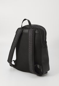 Black backpack featuring a textured mesh back, padded straps, a streamlined shape, and a zip closure at the top for easy access.