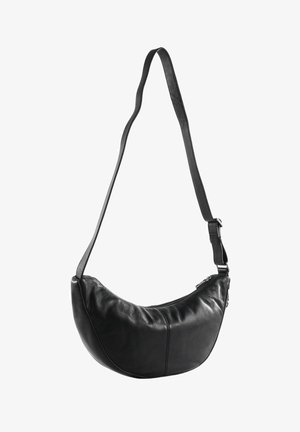Zwarte leren schoudertas in halvemaanvorm met verstelbare band en ritssluiting.