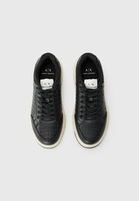 Adidași din piele neagră cu branding embosat, vârf rotund, părți laterale cu model și talpă din cauciuc gri. Legați cu șireturi negre.