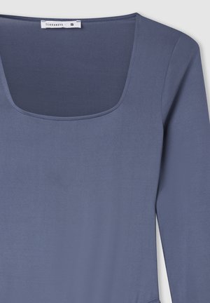Maglietta blu a maniche lunghe con scollo quadrato, realizzata in tessuto morbido. Presenta una texture liscia e un design semplice. L'etichetta indica la taglia S.