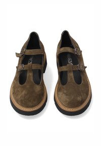 Bruine suede schoenen met twee gespsluitingen, ronde neus en zwarte rubberen zool. Contraststiksel langs de rand. Geen hak.