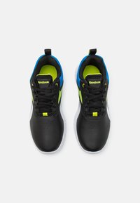 Černé sportovní boty s hladkým koženým svrškem, jasně modrými akcenty a neonově zelenými prvky. Mají černé šněrování a strukturovanou podrážku.