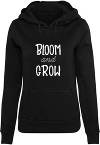 Fekete kapucnis pulóver elülső zsebbel, fehér felirattal, amely így szól: "BLOOM and GROW". Puha, kényelmes anyagból készült.