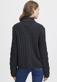 Dark gray ribbed sweater featuring a high collar, cable knit details along the back and sleeves, and a relaxed fit.