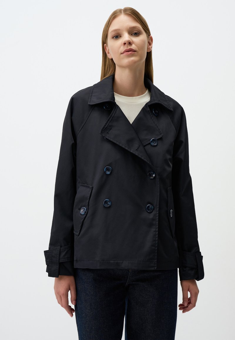 Granatowy dwurzędowy trencz z dużymi guzikami, bocznymi kieszeniami i wykładanym kołnierzem. Gładki materiał o zdefiniowanym kroju.