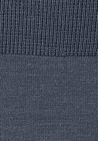 Tissu bleu texturé montrant un motif nervuré en haut, transitionnant vers une texture plus lisse en bas. La couleur est d'un bleu marine profond.