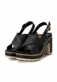 Sandalias de plataforma negras con diseño de tiras cruzadas, tela texturizada, correa de tobillo ajustable y suela beige con detalles de costura.