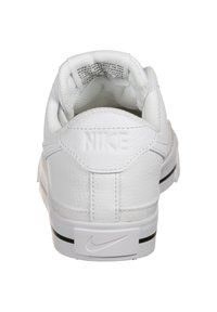 Bílé tenisky Nike s texturovaným koženým svrškem, polstrovaným límcem a logem na patě. Mají černou podešev a měkkou podšívku.