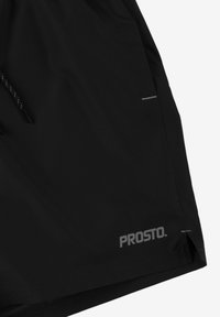 Czarne szorty wykonane z lekkiego materiału, z elastycznym pasem, regulowanym sznurkiem i odblaskowym logo na dolnym brzegu.