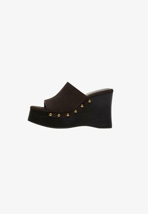 Sandale compensée marron foncé pour femme avec bout ouvert, semelle épaisse en bois et clous en laiton sur le côté.