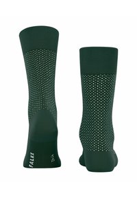 Dunkelgrüne Socken mit geripptem Bund, gepunktetem Muster und verstärktem Zehen- und Fersenbereich. Das Material wirkt dehnbar und glatt. Das Markenlogo ist sichtbar.