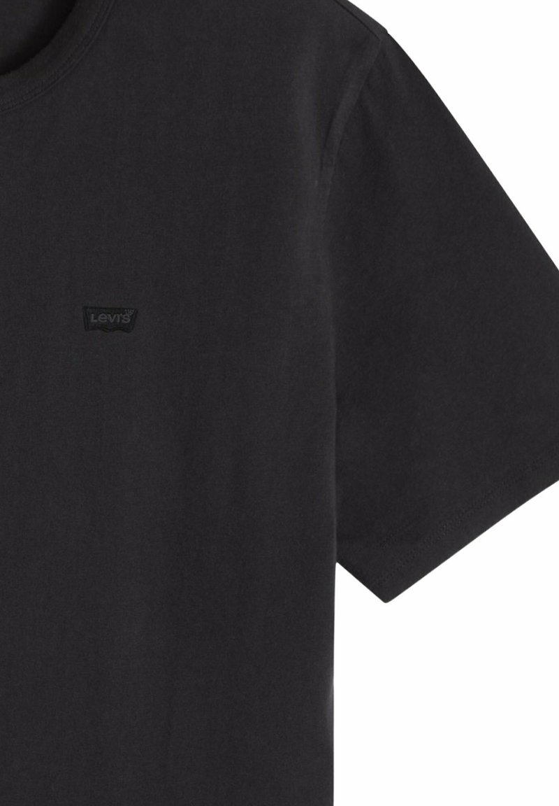 Camiseta negra de manga corta con cuello redondo y pequeño logo negro de Levi's en el lado izquierdo del pecho.