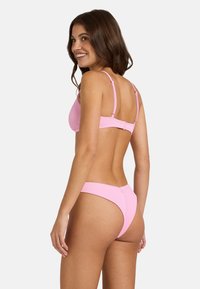 Roza rebrasta bikinija nastavak, ki vsebuje trikotni zgornji del z nastavljivimi naramnicami in nizko pasom z minimalno pokritostjo. Gladek material.