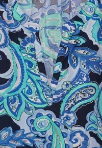 Blusa multicolore con un motivo floreale paisley in tonalità di blu e verde, con scollo a V e tessuto leggero e testurizzato.