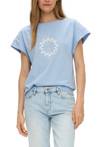 Lichtblauwe katoenen T-shirt met oversized mouwen en witte tekstgrafiek met een zonmotief en de zin in een cirkelvormige lay-out.