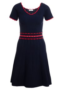 Marinblå stickad klänning med korta ärmar, röd dekorativ halsringning och midja, med en plisserad kjol. Randig detalj runt midjan med vita accenter.