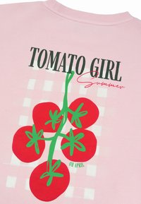 Ροζ ύφασμα με μαύρο κείμενο «TOMATO GIRL» και κόκκινη καλλιγραφική λέξη «summer» πάνω από μια εικονογραφημένη πράσινη φυλλωσιά ντομάτας με πέντε κόκκινες ντομάτες.