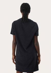 Abito nero a maniche corte realizzato in tessuto morbido, presenta una vestibilità comoda con colletto e un design della schiena asimmetrico.